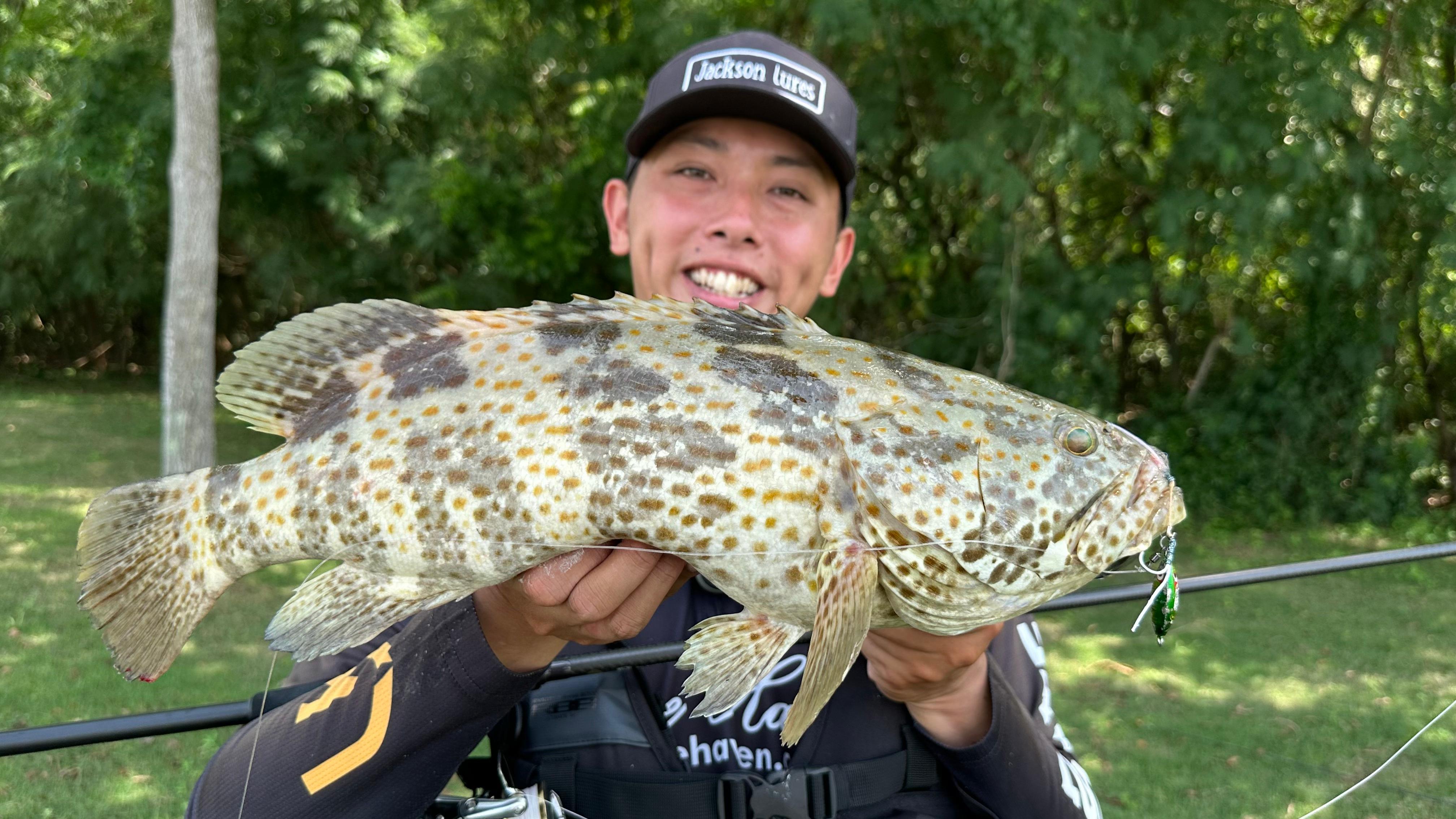 Ryan Ngler catches an orange spotted grouper in the Southern Islands on the 40g Bozles Matsukaze Tungsten Jig (Green and Gold), paired with the Gamakatsu Assist 59 Light Fibre Plus Assist Hooks, Size 1/0